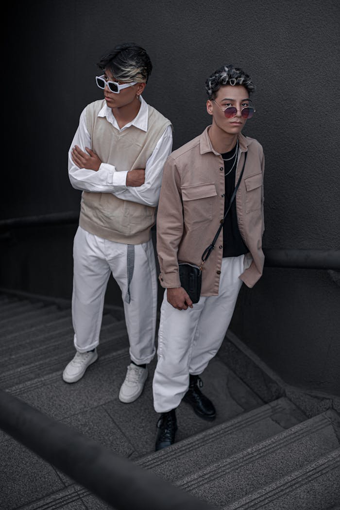 services-02 Stylish young men in beige and white outfits posing on stairs, embodying modern fashion trends.
