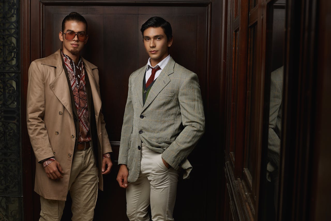 heros-img Two men in fashionable suits posing indoors, showcasing elegance and style.