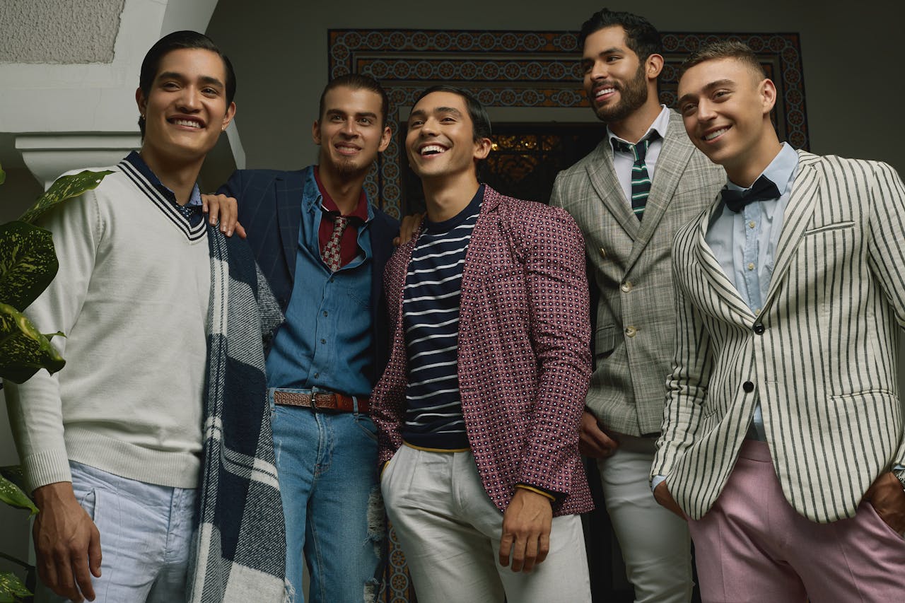 about-us-02 Five men in fashionable attire posing indoors, exuding confidence and style.